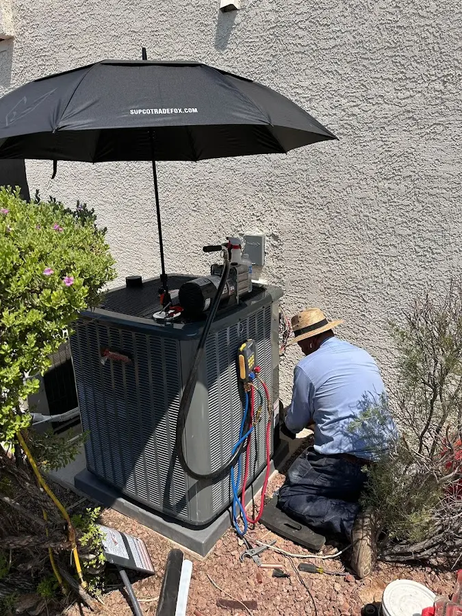 HVAC technician performing outdoor AC maintenance in Schofield Barracks
